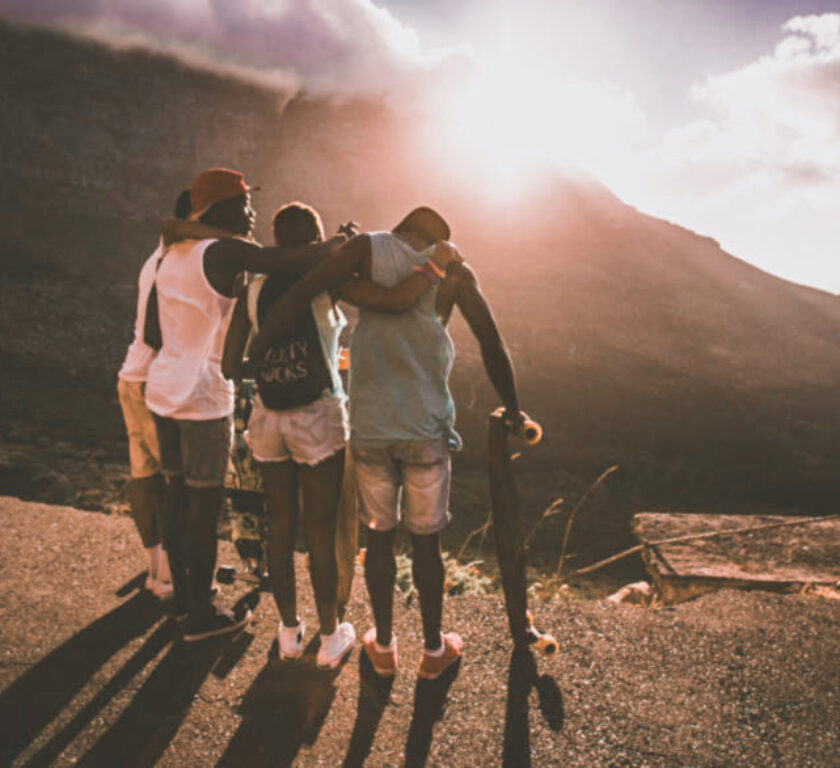 Group of happy teen friends standing together with longboards