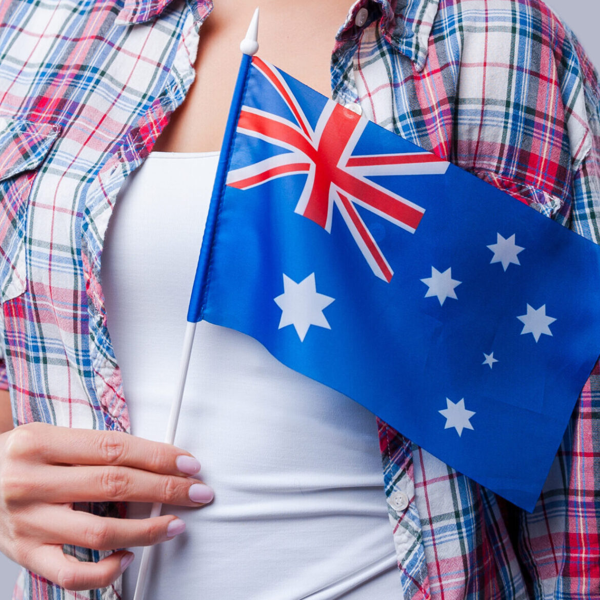 Beauty with Australian flag. Happy young women flag of Australia while standing against grey background