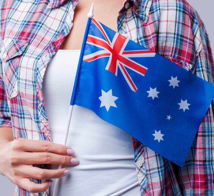 Beauty with Australian flag. Happy young women flag of Australia while standing against grey background